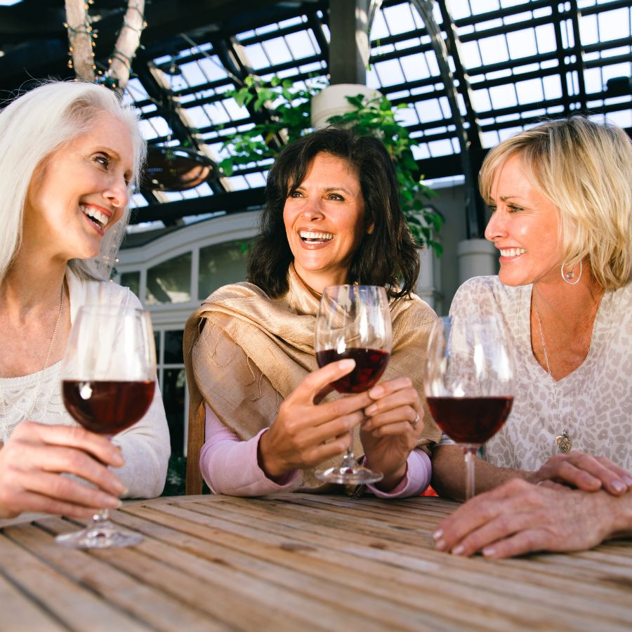 three senior women drinking wine
